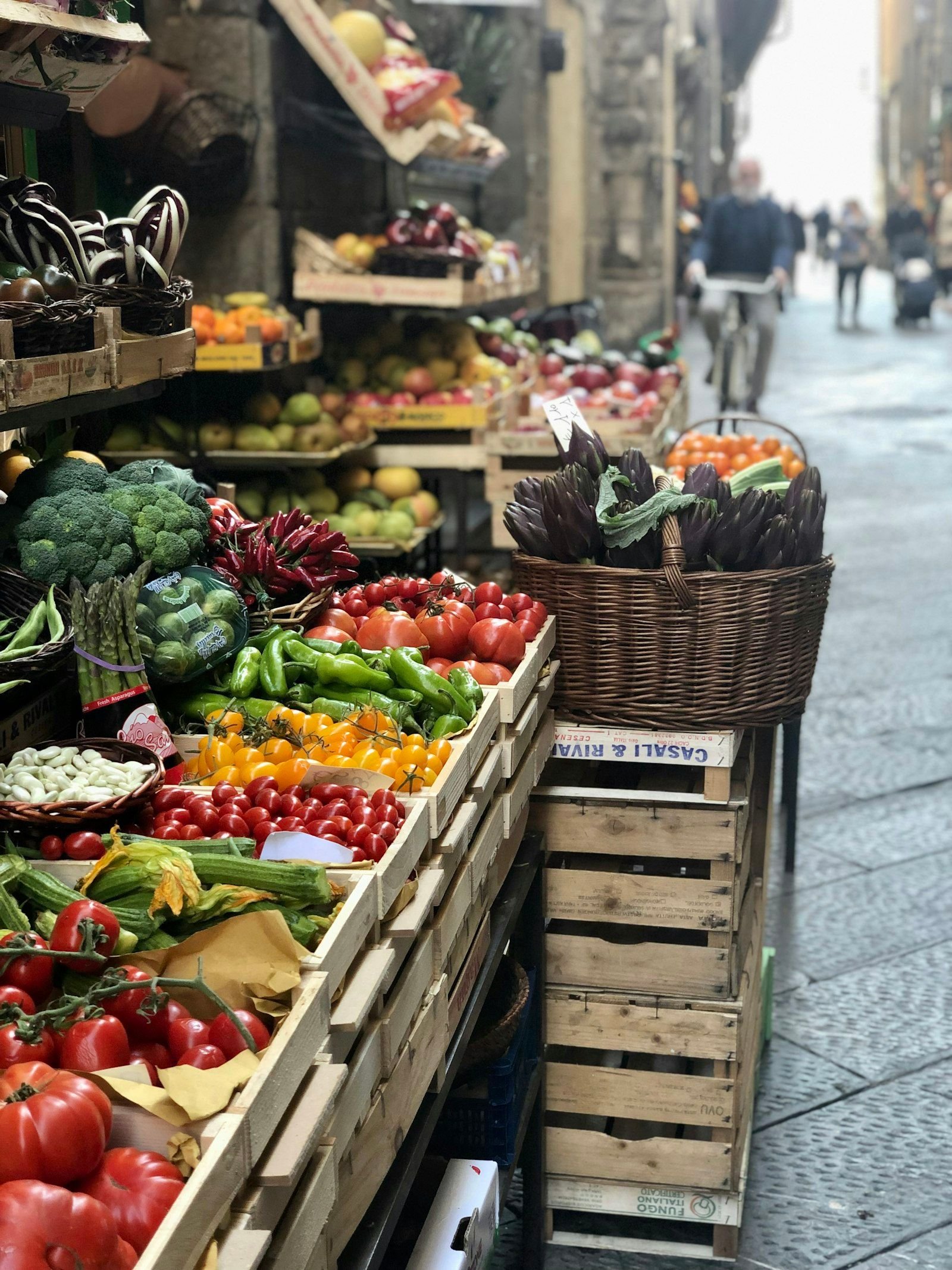 Bottega italiana con cassette di frutta e verdura di stagione esposte sulla strada